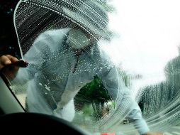 Jóvenes con cubrebocas trabajan limpiando parabrisas en una calle de la Ciudad de México. EFE/J. Núñez