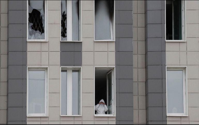 Un médico se asoma desde una ventana del sexto piso del hospital San Jorge, donde ayer inició un incendio. EFE/A. Maltsev