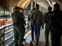 Elementos de la Patrulla Fronteriza de EU escoltan a solicitantes de asilo que cruzan desde Ciudad Juárez, luego del cierre fronterizo a viajes no esenciales. AFP/ARCHIVO