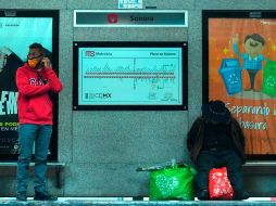 Dos personas esperan su transporte en una estación de Metrobús, en la Ciudad de México. EFE/J. Núñez