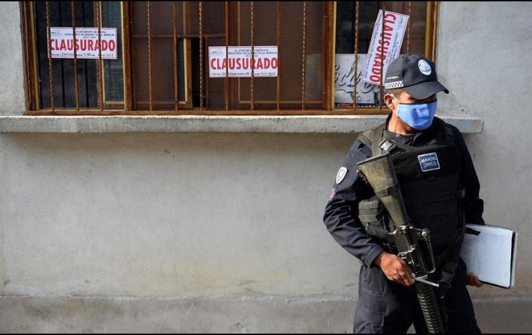 Un agente de la Policía estatal resguarda una tienda clausurada donde se vendía alcohol adulterado en el municipio de Jonacatepec, Morelos. EFE/T. Rivera