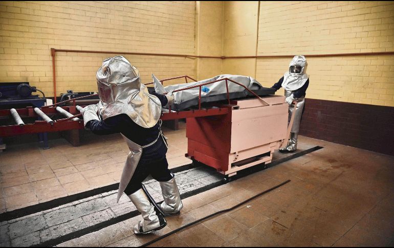 MEDIDAS. Trabajadores de un crematorio en la Ciudad de México incineran el cuerpo de una víctima de COVID-19. AFP