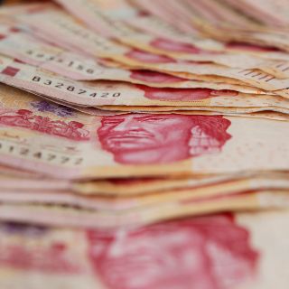 Peso gana y cotiza en 23.39 por dólar