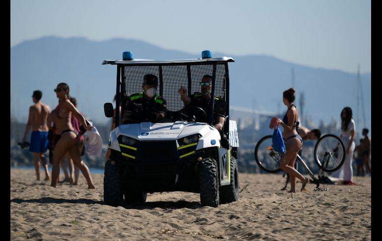 Policías patrullan una playa. AFP/L. Gene