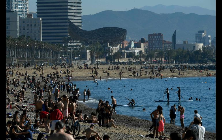 Personas toman el Sol en la playa Barceloneta. AFP/L. Gene