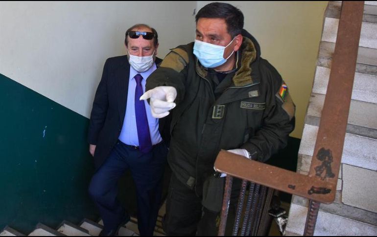 Policías bolivianos custodian al hasta ahora ministro interino de Salud de Bolivia, Marcelo Navajas (i), quien fue arrestado este miércoles en un caso de supuesta corrupción. EFE