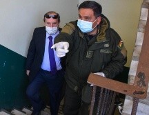 Policías bolivianos custodian al hasta ahora ministro interino de Salud de Bolivia, Marcelo Navajas (i), quien fue arrestado este miércoles en un caso de supuesta corrupción. EFE