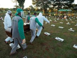 Trabajadores del cementerio Campo de Esperanza entierran una víctima de COVID-19 este jueves, en Brasilia. EFE/J. Alves