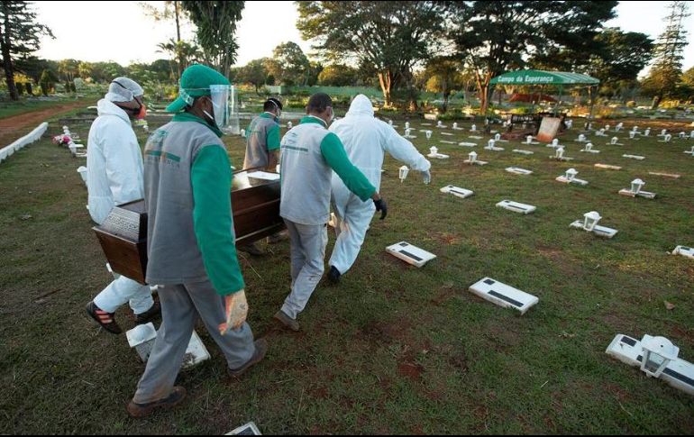 Trabajadores del cementerio Campo de Esperanza entierran una víctima de COVID-19 este jueves, en Brasilia. EFE/J. Alves