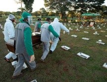 Trabajadores del cementerio Campo de Esperanza entierran una víctima de COVID-19 este jueves, en Brasilia. EFE/J. Alves