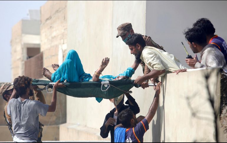 Voluntarios trasladan a uno de los heridos por la colisión de la aeronave en Karachi. AP/F. Khan