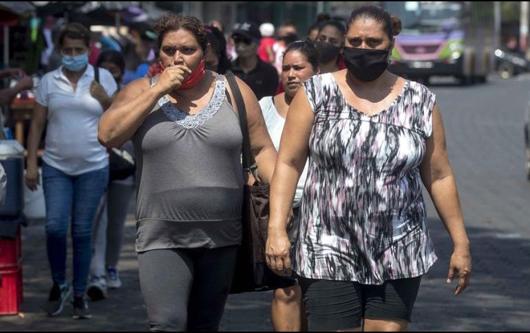 Mujeres caminan por un mercado mientras utilizan tapabocas como medida de prevención ante el COVID-19, en Managua. EFE/J. Torres