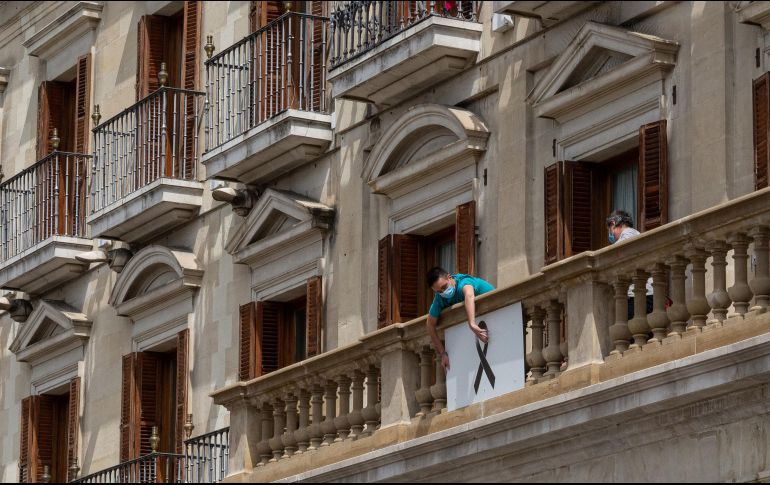 Un operario coloca una pancarta con un crespón negro en el Ayuntamiento para sumarse al luto nancional español. NTX / I. Berasaluce