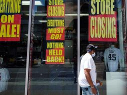 Un hombre pasa junto a una tienda con anuncios de liquidación de mercancía, en Nueva York. EFE/J. Lane