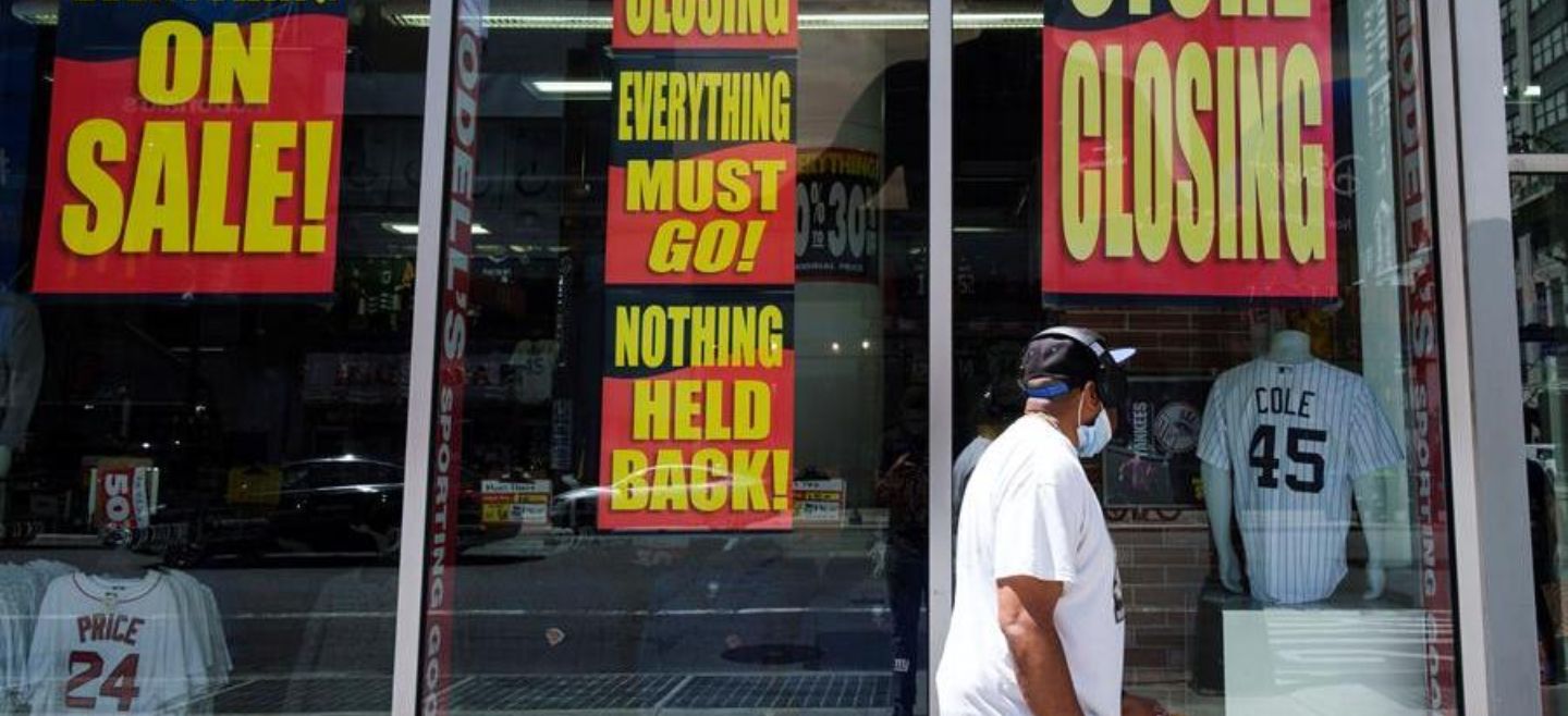 Un hombre pasa junto a una tienda con anuncios de liquidación de mercancía, en Nueva York. EFE/J. Lane