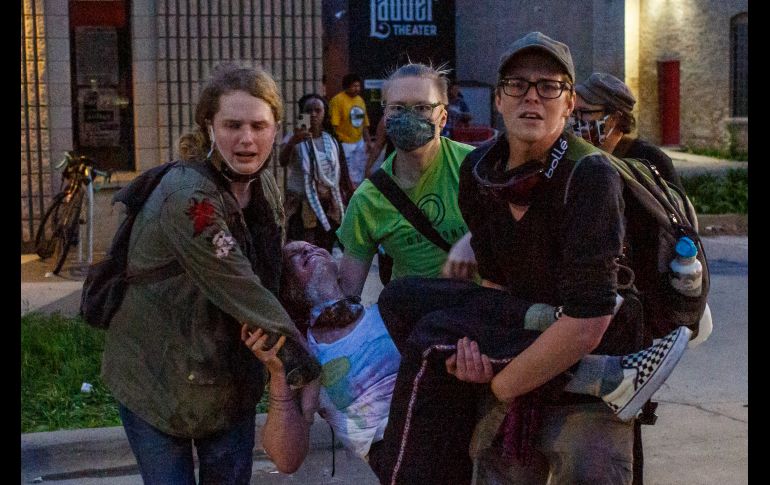 Manifstantes cargan a una mujer herida durante las protestas. AFP/K. Yucel