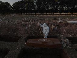 Un sepulturero entierra un féretro con una víctima de COVID-19 en el cementerio de Caju este viernes en la zona norte de Río de Janeiro. EFE/A. Lacerda