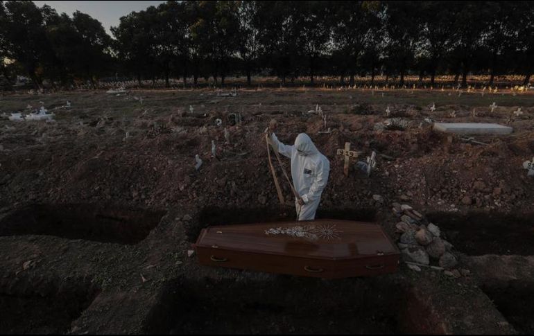 Un sepulturero entierra un féretro con una víctima de COVID-19 en el cementerio de Caju este viernes en la zona norte de Río de Janeiro. EFE/A. Lacerda