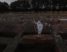 Un sepulturero entierra un féretro con una víctima de COVID-19 en el cementerio de Caju este viernes en la zona norte de Río de Janeiro. EFE/A. Lacerda