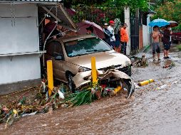 Un auto arrastrado por las aguas en  San Salvador. AFP/Y. Cortez