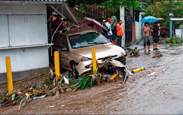 Un auto arrastrado por las aguas en  San Salvador. AFP/Y. Cortez