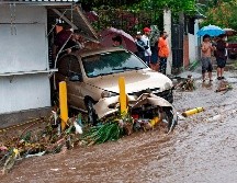 Un auto arrastrado por las aguas en  San Salvador. AFP/Y. Cortez