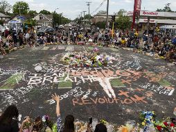 Personas se congregan hoy alrededor del sitio en Minneapolis donde el afroamericano George Floyd murió a manos de un policía blanco. AFP/S. Maturen