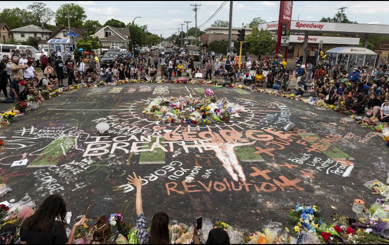 Personas se congregan hoy alrededor del sitio en Minneapolis donde el afroamericano George Floyd murió a manos de un policía blanco. AFP/S. Maturen
