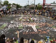 Personas se congregan hoy alrededor del sitio en Minneapolis donde el afroamericano George Floyd murió a manos de un policía blanco. AFP/S. Maturen