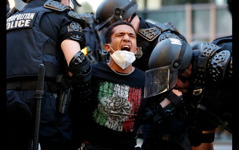 Un manifestante arrestado luego de entró en vigor el toque de queda para evitar disturbios. AP/A. Brandon