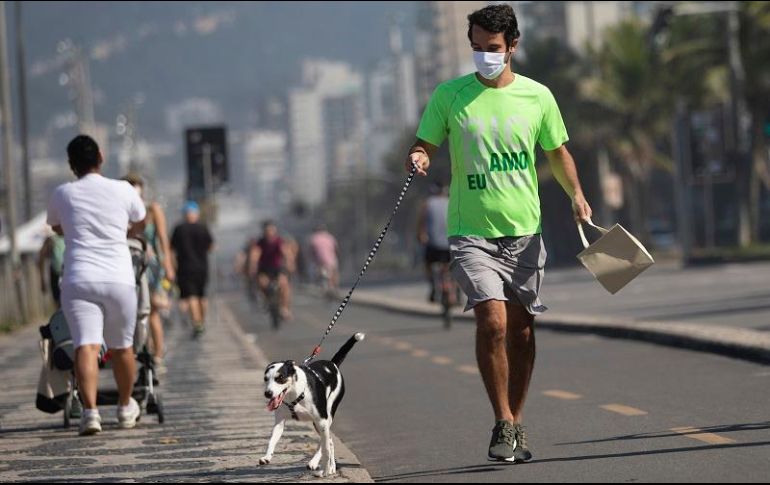 Un hombre pasea a su perro en Río de Janeiro. El plan de desconfinamiento, aunque ordenado, recibió reacciones de desconfianza ante la rapidez de los contagios. AP/S. Izquierdo