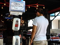 A los clientes se les revisa su temperatura, y lavan sus manos y  zapatos. EL INFORMADOR / E. Barrera