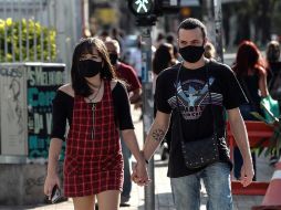 Una pareja con tapabocas camina en una calle, este lunes, en la ciudad de Sao Paulo. EFE/S. Moreira