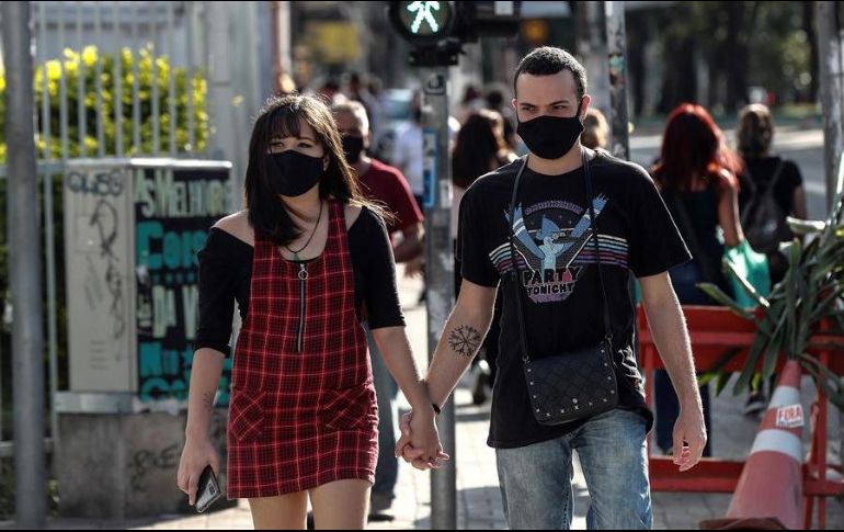 Una pareja con tapabocas camina en una calle, este lunes, en la ciudad de Sao Paulo. EFE/S. Moreira