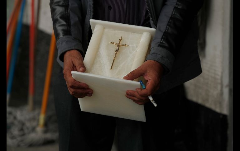 Un hombre cuyo familiar murió de coronaviturs sostiene una urna mientras espera en el crematorio. AP/M. Ugarte