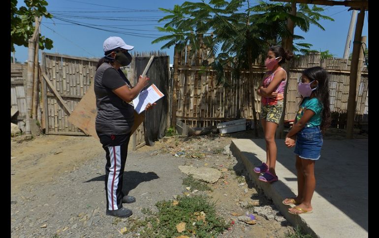 Con el alumno a dos metros de distancia, Espinoza coloca la pizarra donde puede y repite la clase que horas antes había impartido por Zoom. EFE/M. Pin