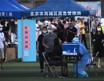 Personal de salud toma muestras para pruebas de coronaviurs en un centro deportivo de Pekín, realizadas a personas que visitaron o viven cerca del mercado Xinfadi. AFP/N. Celis