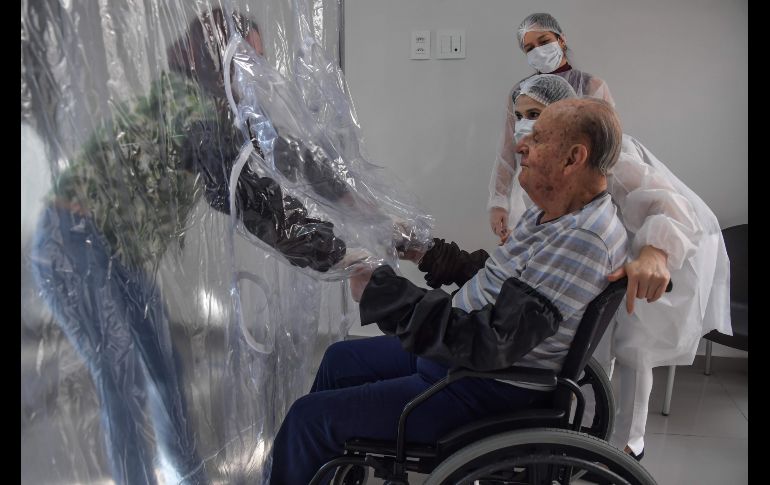 Residentes y visitantes deben usar guantes protectores con mangas largas. Suzane Lisboa (i) con su padre Raul Lisboa, de 89. AFP/N. Almeida
