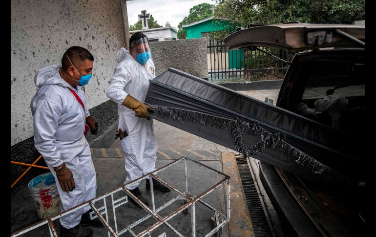 Trabajadores del cementerio de San Nicolás Tolentino, en Iztapalapa, reciben un cuerpo de una víctima de COVID-19. A continuación el proceso para su incineración. AFP/P. Pardo