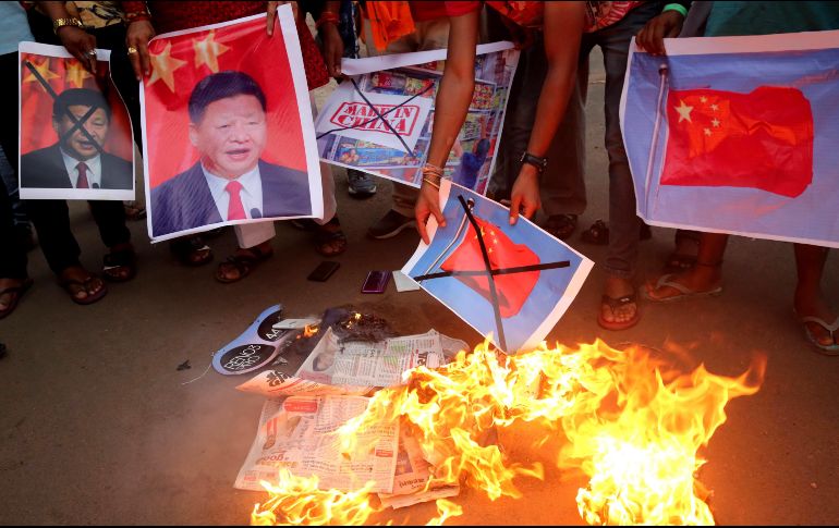 Manifestantes queman imágenes del presidente chino Xi Jinping y de banderas de China en protesta por la muerte de soldados indios. EFE/EPA/S. Gupta