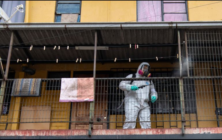 Un trabajador desinfecta viviendas en Santiago. Conjuntos de edificios altos con varios apartamentos por piso se han convertido en foco de contagio. AFP/ARCHIVO