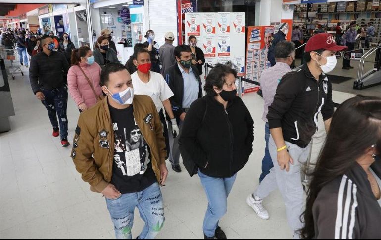 Compradores hacen fila para ingresar a un almacén este viernes en Bogotá. Miles de personas desafiaron el contagio del COVID-19 haciendo largas filas durante el primer Día sin IVA. EFE/C. Ortega