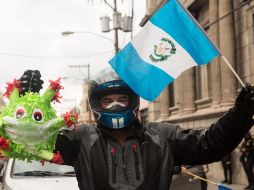 Un hombre sostiene una piñata del coronavirus frente al Congreso, este jueves en Ciudad de Guatemala, durante una manifestación. EFE/E. Biba