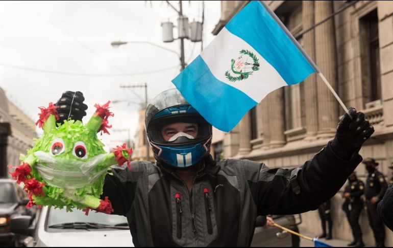 Un hombre sostiene una piñata del coronavirus frente al Congreso, este jueves en Ciudad de Guatemala, durante una manifestación. EFE/E. Biba
