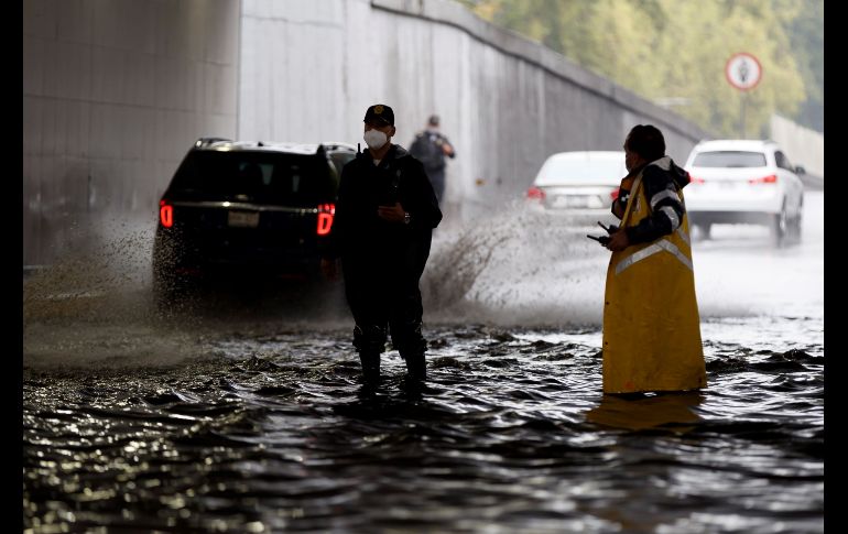 Elementos de la Policía de Vialidad agilizan el trafico este lunes, en un encharcamiento. EFE/J. Méndez