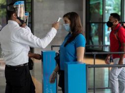Las personas que deseen ingresar a un centro comercial deberán pasar por filtros sanitarios, entre los que se encuentra la toma de temperatura. EFE/R. Peña