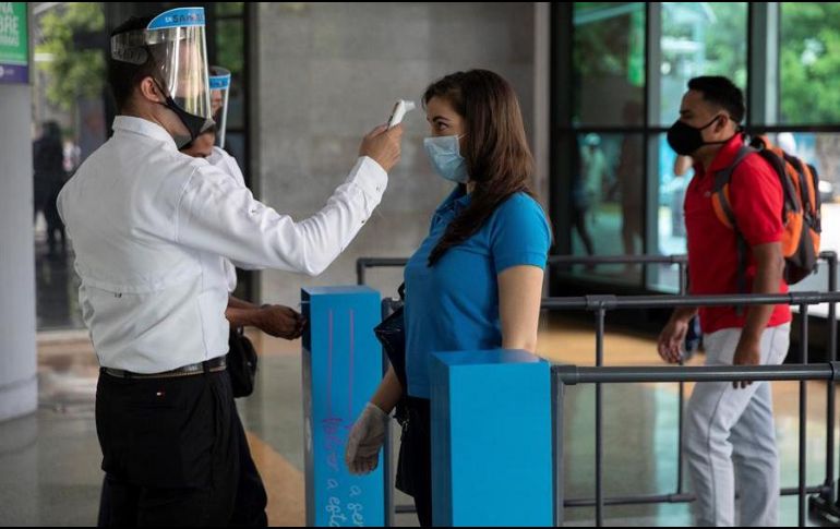 Las personas que deseen ingresar a un centro comercial deberán pasar por filtros sanitarios, entre los que se encuentra la toma de temperatura. EFE/R. Peña
