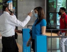 Las personas que deseen ingresar a un centro comercial deberán pasar por filtros sanitarios, entre los que se encuentra la toma de temperatura. EFE/R. Peña
