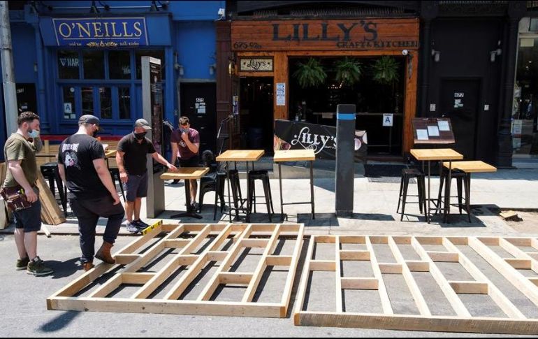Trabajadores de un restaurante elaboran una zona especial para comer al aire libre. EFE/J. Lane