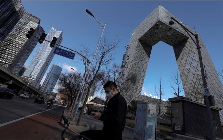 Un hombre con tapabocas camina cerca del edificio de la Televisión Central de China (CCTV) en el distrito central de negocios (CBD) en Beijing, China. EFE/W. Hong